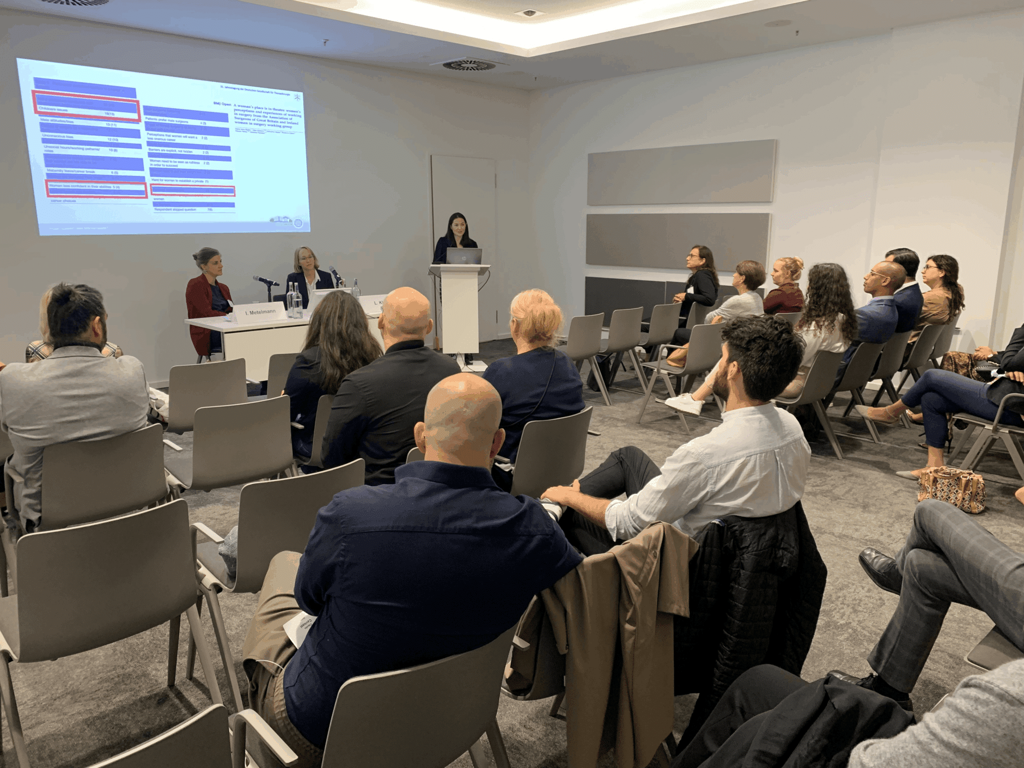 Bild FIT-Webseite 2 Teilnehmer sitzen in einem Konferenzraum und hören einer Präsentation zu.