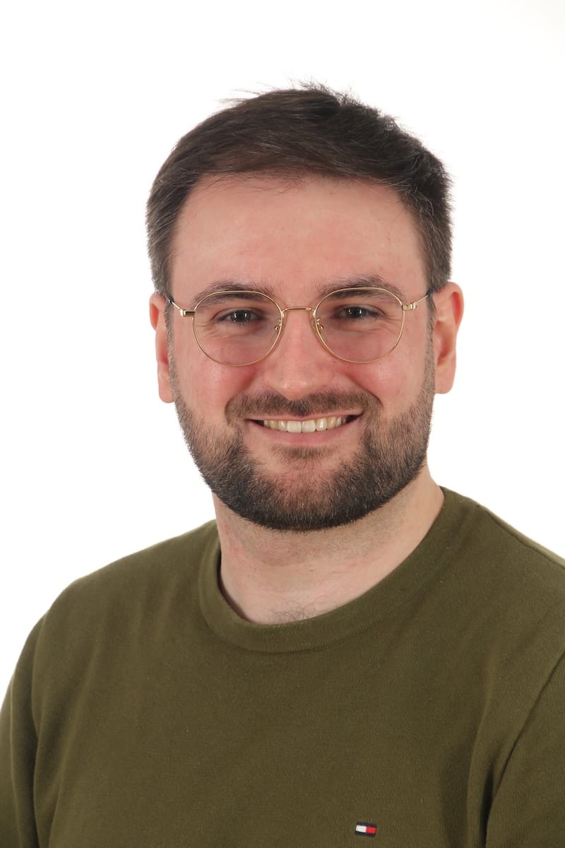 Foto Gareth Edwards Porträt eines lächelnden Mannes mit Brille vor weißem Hintergrund.